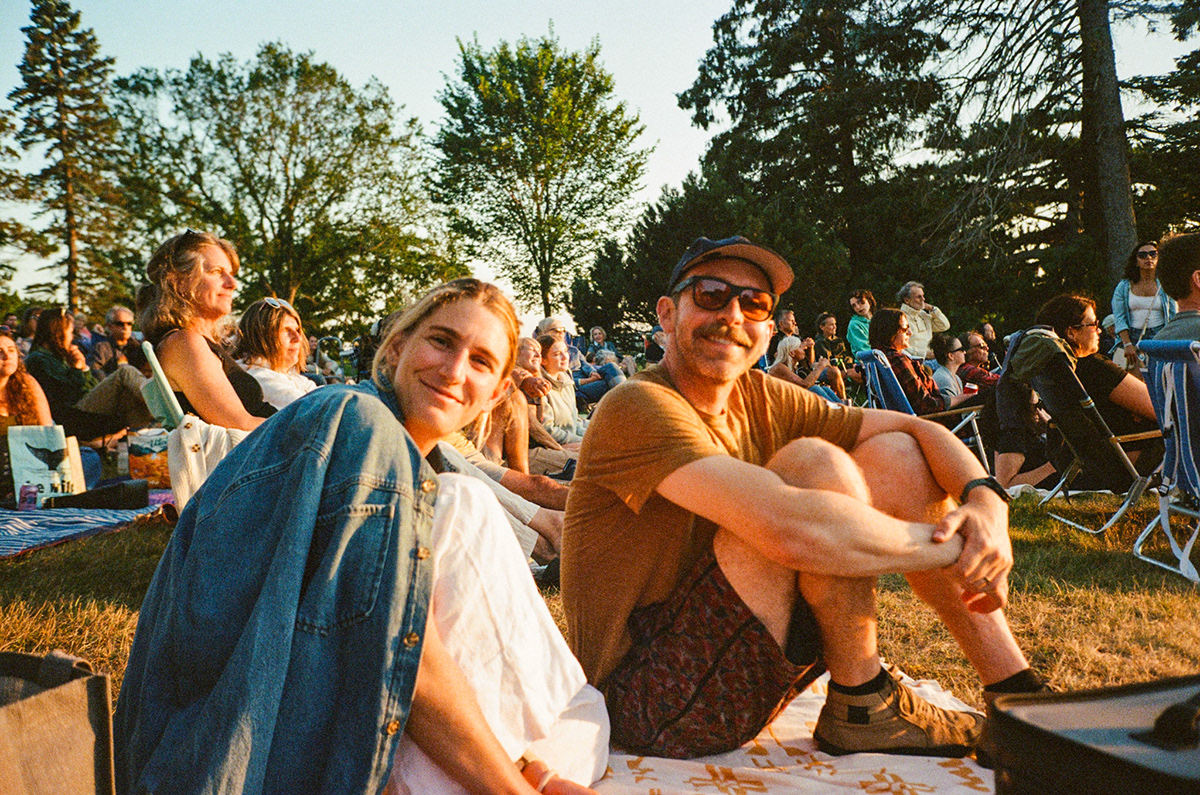 People gathered outdoors at sunset